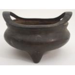 A CHINESE BRONZE TRIPOD INCENSE BURNER the compressed body with curved sweeping handles and on three