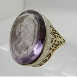 A YELLOW AND WHITE METAL AMETHYST INTAGLIO RING carved with a maiden in profile, amethyst approx