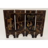 A CHINESE LACQUERED FOUR-FOLD TABLE SCREEN carved and coloured with figures in a garden and within a