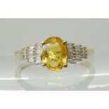 A 9CT YELLOW SAPPHIRE AND DIAMOND RING the sapphire measures approx 7mm x 5mm x 3mm, with baguette