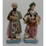 A PAIR OF CONTINENTAL FIGURAL QUILL HOLDERS modelled as a couple in Arabic dress, each with a hole