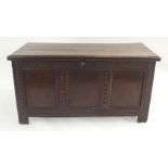 AN OAK BLANKET CHEST the hinged top above a three panel front beneath a foliate frieze and divided