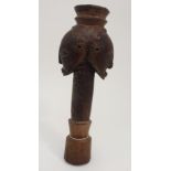 AN AFRICAN CARVED AND STAINED CARVING depicting a double headed mask on a tapering stem, 33cm high