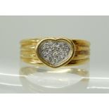 A YELLOW METAL DIAMOND SET HEART RING stamped 750 (18ct) with a diamond accent pave set heart,