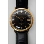 A GOLD PLATED OMEGA AUTOMATIC CONSTELLATION WATCH WITH BLACK DIAL and gold coloured baton numerals