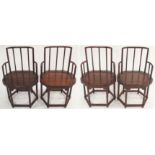 A SET OF FOUR CHINESE HARDWOOD CHAIRS each with rail backs and arms above a solid shaped seat and on