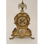 A VICTORIAN GILT METAL AND PORCELAIN MANTEL CLOCK the front with decoration of cherubs surrounded by