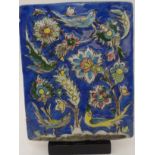 AN ISNIK RELIEF MOULDED POTTERY TILE decorated with birds amongst flowering branches, 20th