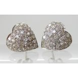 A PAIR OF HEART SHAPED PAVE DIAMOND SET EARRINGS mounted in white metal with galleried mount, set