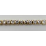 AN 18CT GOLD DIAMOND LINE BRACELET set with estimated approx 10.63cts of brilliant cut diamonds in