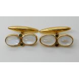 A PAIR OF YELLOW METAL MOONSTONE AND EMERALD CUFFLINKS each moonstone is approx 10mm x 7mm, length