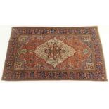 AN EASTERN RUG WITH CENTRAL MEDALLION in a field with floral designs and stylised birds with a