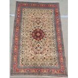 A CREAM GROUND KESHAN RUG with red central medallion and border, 208cm x 132cm Condition Report: