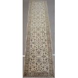A CREAM GROUND FINE KESHAN RUNNER with allover floral design, 412cm x 105cm Condition Report: