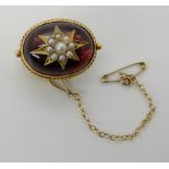 A VICTORIAN GARNET CARBUNCLE AND PEARL BROOCH made in bright yellow metal with a pearl star set into