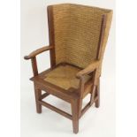 AN OAK ORKNEY CHAIR with traditional woven marram grass, curved arms, above a lift-out seat and
