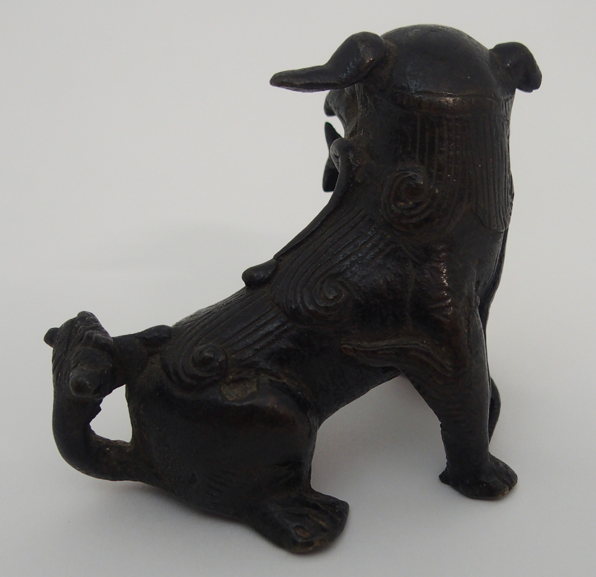 A CHINESE BRONZE SHISHI modelled seated and holding a brocade ball, 17th/18th Century, 6.5cm high - Image 3 of 5