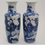 A PAIR OF CHINESE BLUE AND WHITE BALUSTER VASES painted with ladies in a fenced garden and beneath