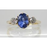 A 9CT SAPPHIRE AND DIAMOND THREE STONE RING the sapphire measures 7.2mm x 5mm x 4mm and set with two