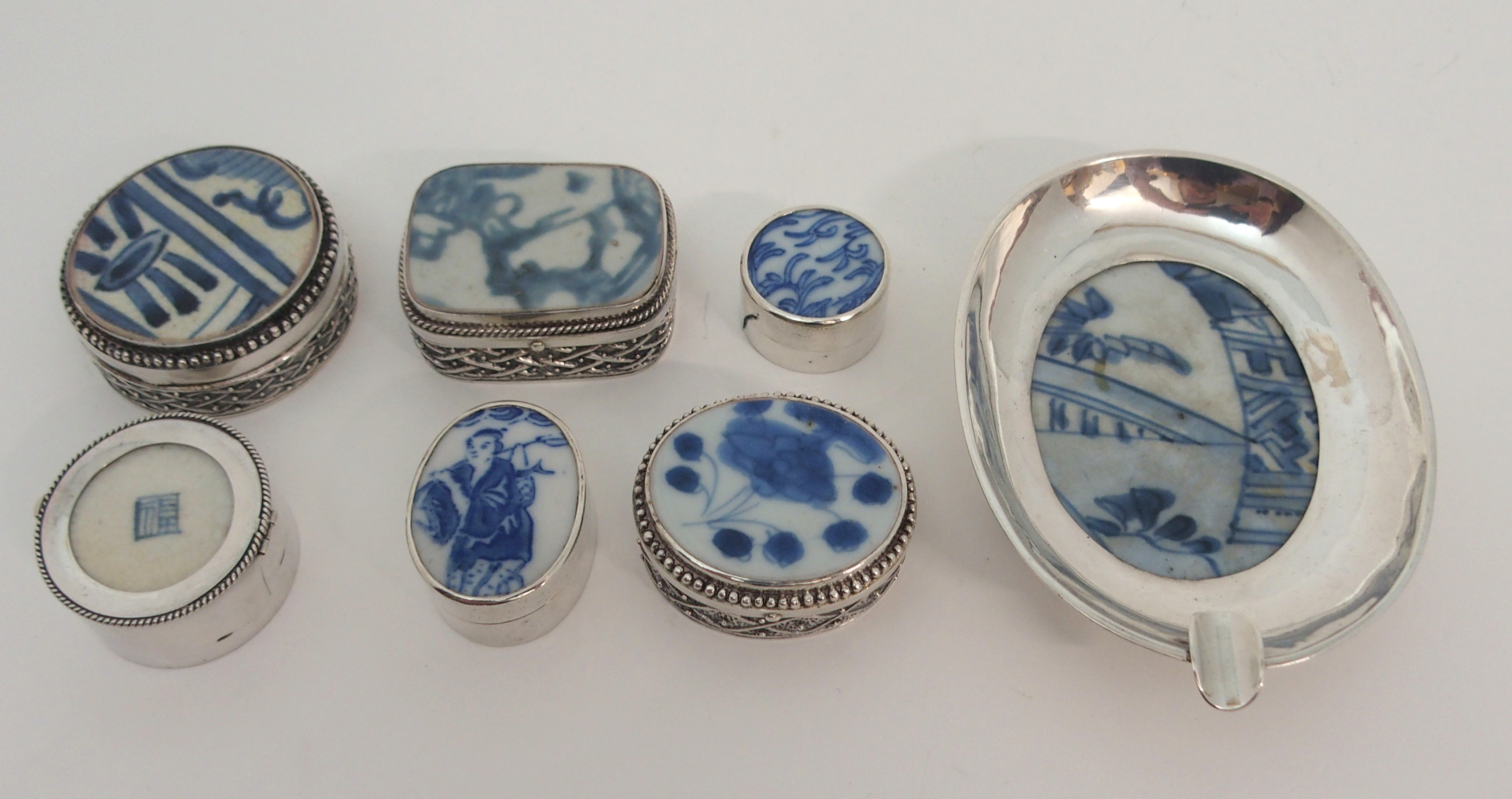 SIX CHINESE SILVER AND CERAMIC MOUNTED BOXES 3 to 5.5cm and an ashtray, 11cm wide all stamped 925 (