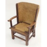 AN OAK ORKNEY CHILD'S CHAIR with traditional woven marram grass, curved arms, above a lift-out