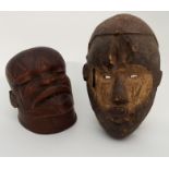A MAKONDE HELMET MASK with tattooed face and pierced mouth, 23cm high and a mask with pierced eye