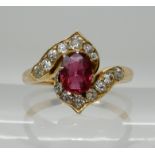 A RUBY AND DIAMOND RING of unusual design, set with an oval cut ruby of 6.2mm x 4.8mm x 2.6mm and