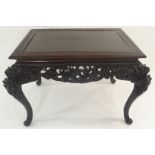 A 19TH CENTURY ASIAN EBONISED TABLE the top with key pattern above a heavy and foliate carved frieze