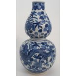 A CHINESE DOUBLE GOURD BLUE AND WHITE VASE painted with a pair of confronting dragons, amongst