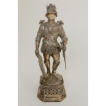 A CONTINENTAL SILVER FIGURE OF A KNIGHT standing in full armour with sword and shield, the helmet