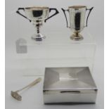 A lot comprising a silver cigarette box, two small trophy cups and a pusher Condition Report: