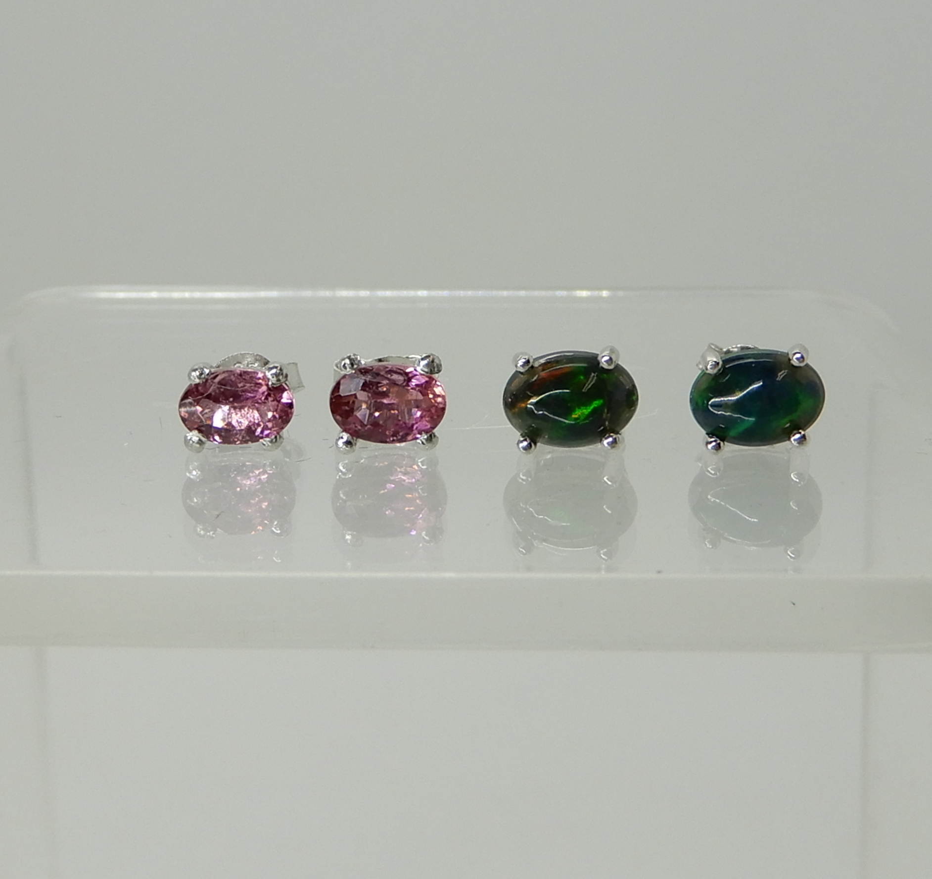 A pair of silver mounted pink gem set earrings and a further pair of 'ammolite' Korite style