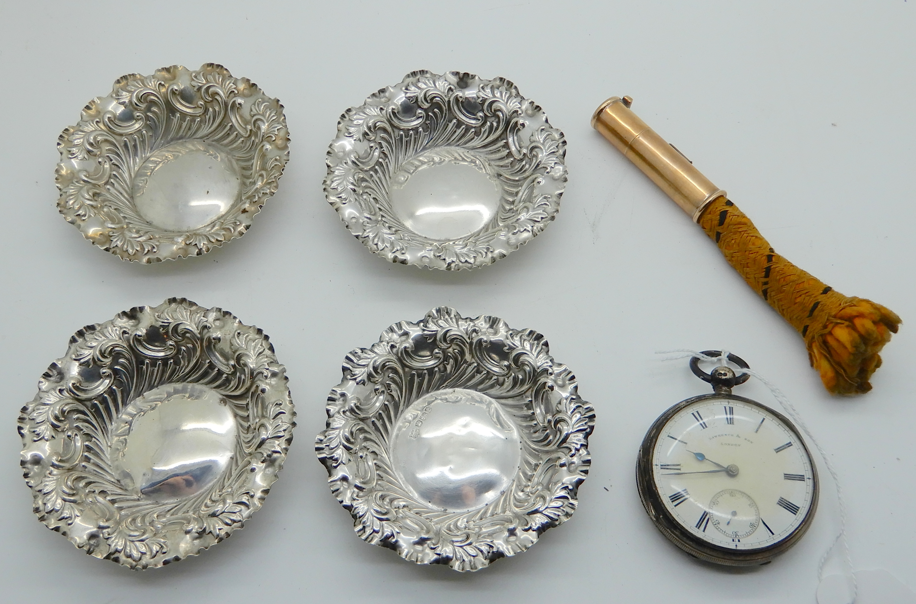 A lot comprising a set of four silver bon bon dishes, (8.5cm diameter), a silver cased pocket