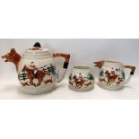 An English pottery three piece teaset decorated with fox hunting scenes Condition Report:
