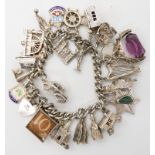 An extensive silver charm bracelet, to include a 10 Shilling note charm Condition Report: Not