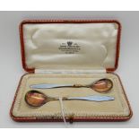 A cased pair of silver and enamel jam spoons Condition Report: Available upon request