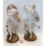 A pair of continental figures of maidens one modelled holding flowers, the other a flaming lamp,
