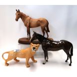 A Royal Doulton matt glazed horse on stand (ear chipped), a Beswick horse and a Lioness Condition