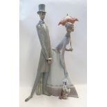 A large Lladro figure of a lady and gent with a puppy Condition Report: Lady missing her foot.