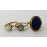 A 9ct gold lapis lazuli ring size H1/2, a yellow metal blue zircon ring size G1/2 and a yellow metal