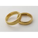 An 18ct gold wedding ring with a decorative edge size L1/2, together with another with a bark