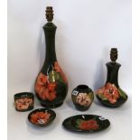 A collection of Moorcroft Hibiscus pattern items including two lap bases, dishes, vases etc