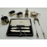 A lot comprising a cased pair of silver and mother of pearl butter knives, sugar tongs and five