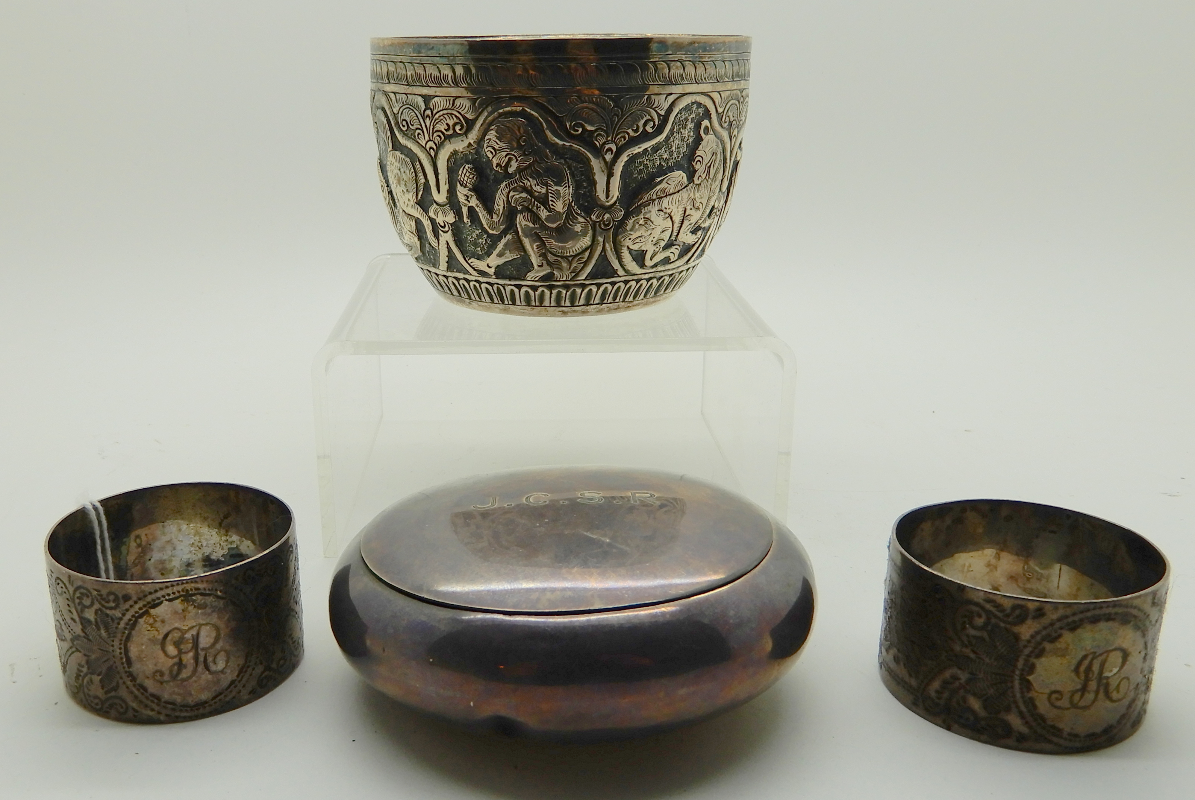 A lot comprising a Burmese white metal bowl, two napkin rings and a circular snuff box Condition