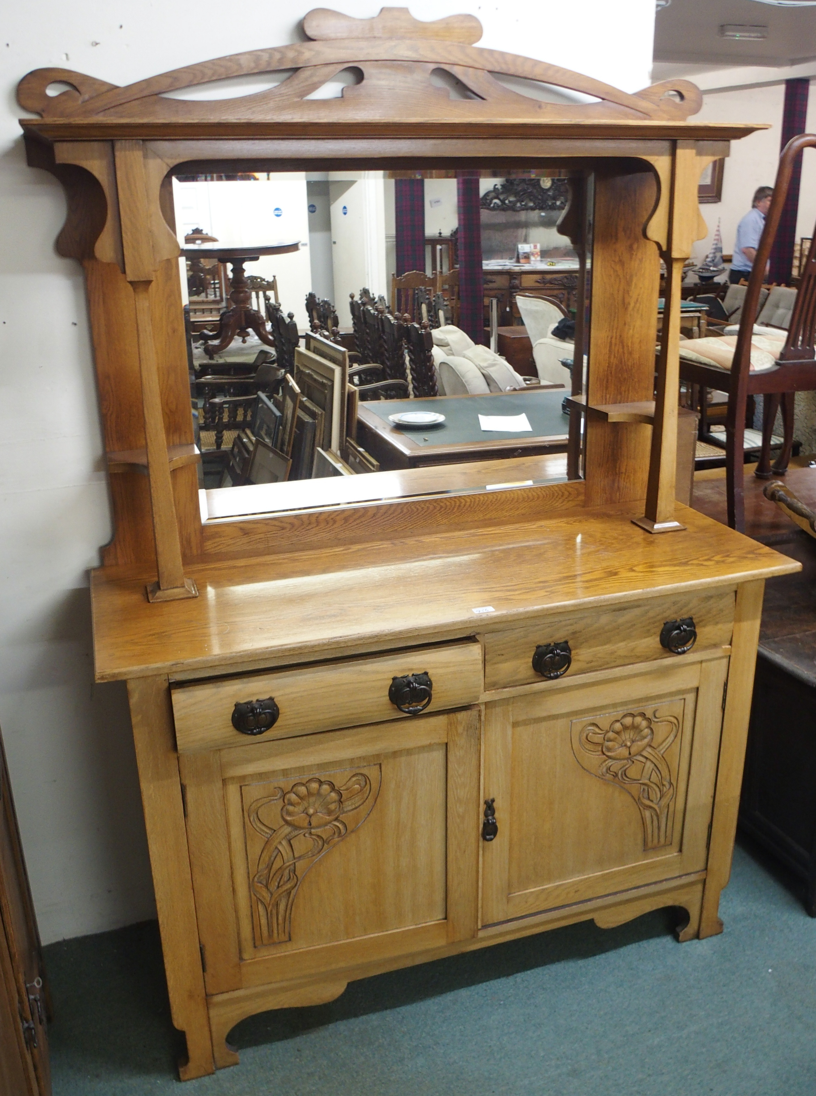 An oak Arts and Crafts mirrored back sideboard with carved panel doors Condition Report: