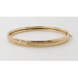 A 9ct gold engraved pattern bangle, inner dimensions 6cm x 4.8cm, weight 6.7gms Condition Report: