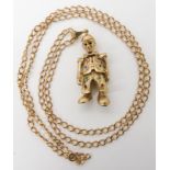 A 9ct gold gem set clown with a bowler hat pendant, length 6cm and a curb chain length 78cm,