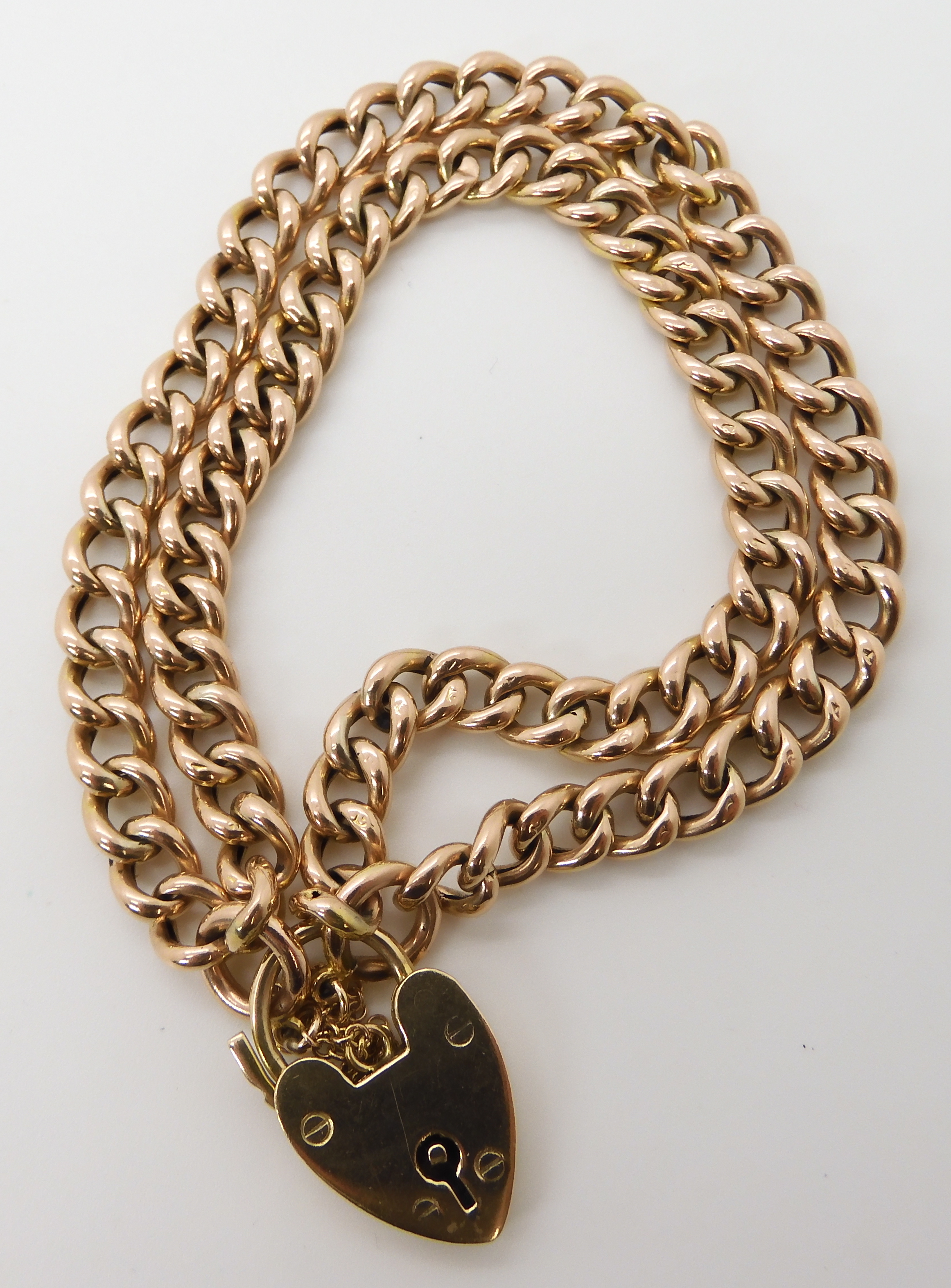 A 9ct gold double curb chain bracelet with a heart clasp length 17cm, weight 15.2gms Condition