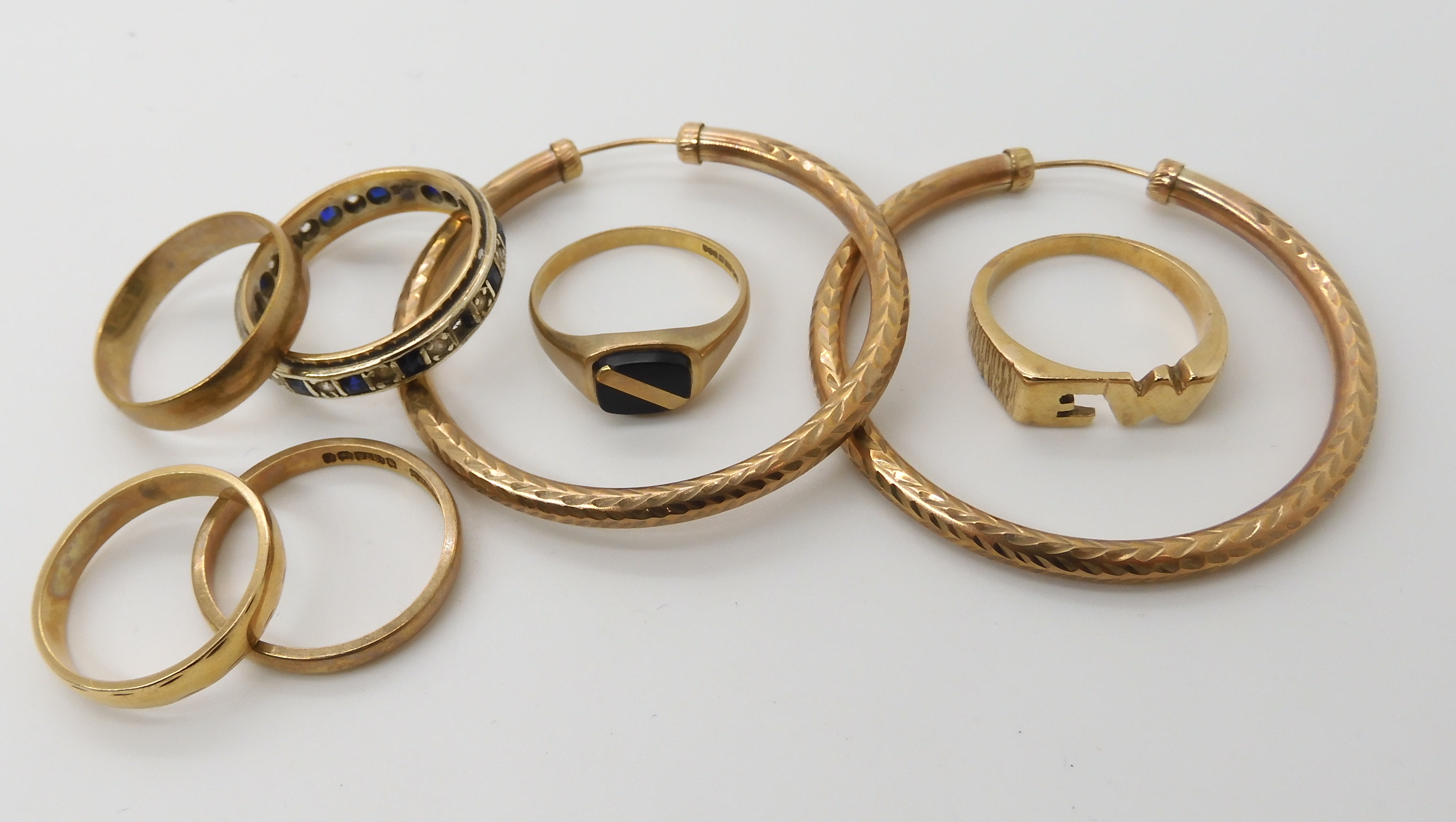 Three 9ct wedding rings, two 9ct gem set rings, a yellow metal signet ring and a pair of earrings