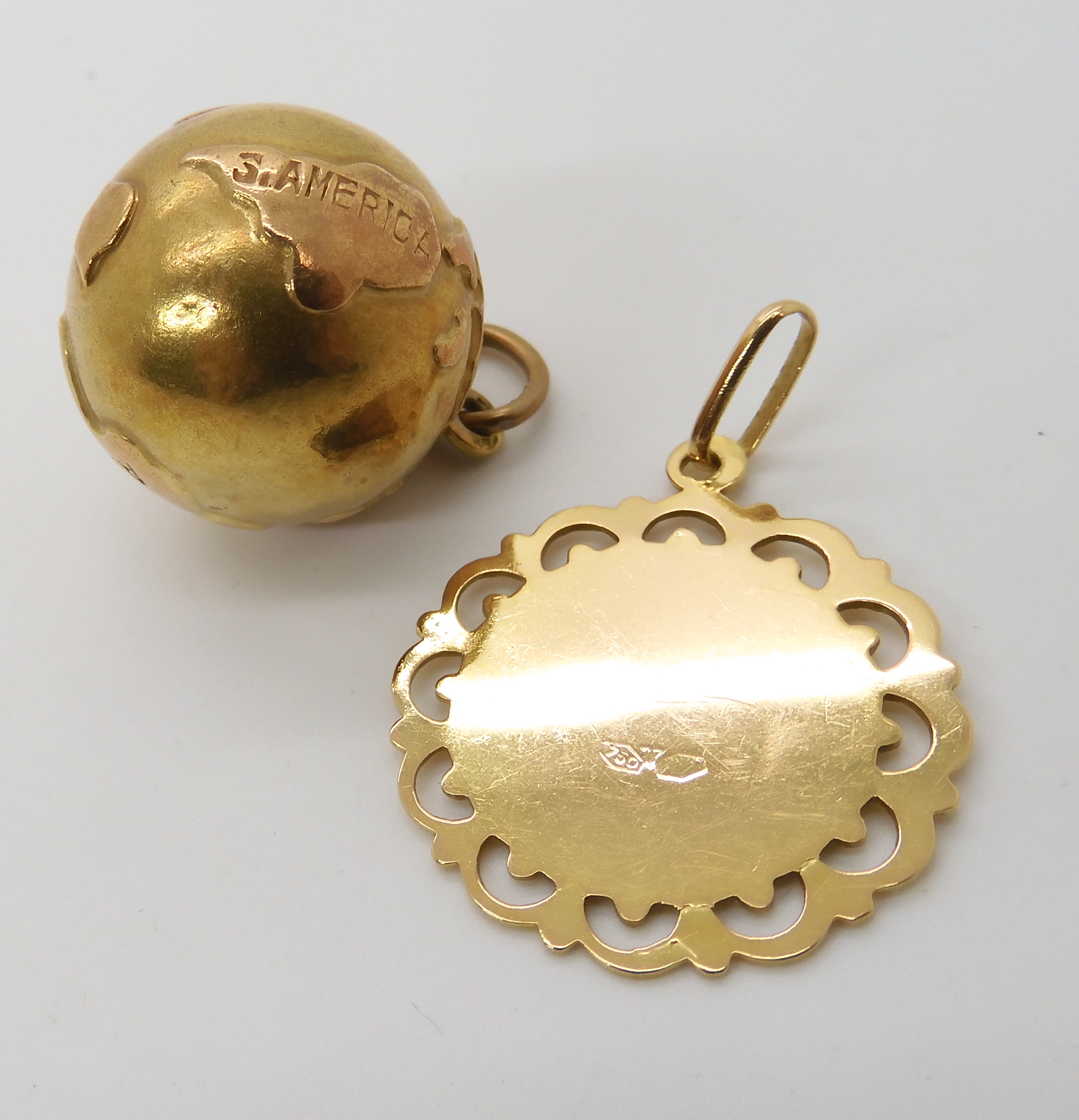 A bright yellow metal world pendant stamped 750, together with an 18ct gold pendant combined - Image 3 of 3